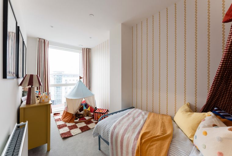 A child's bedroom with a tent, bed, and decorative elements.