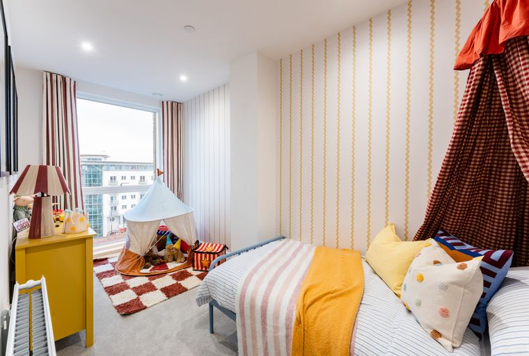 A child's bedroom with a bed, a tent, and toys.