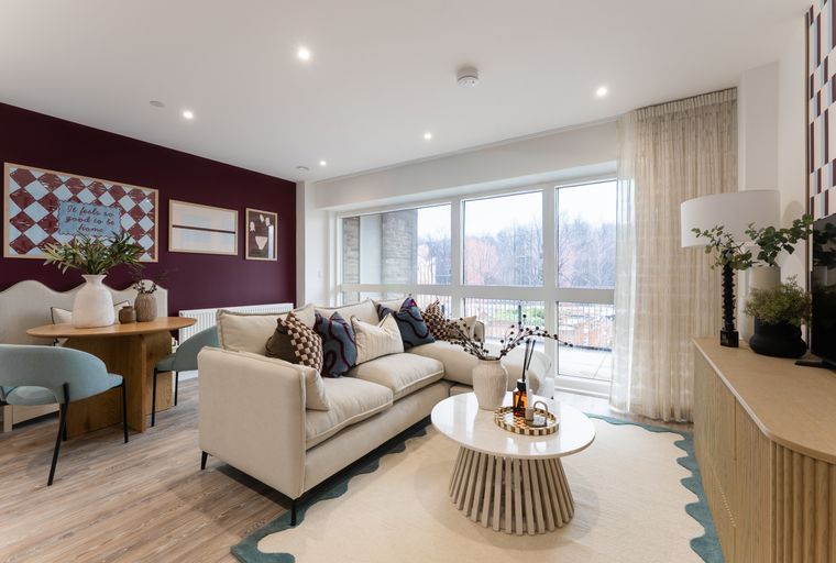 A living room with a sectional sofa, coffee table, dining table, and large windows.