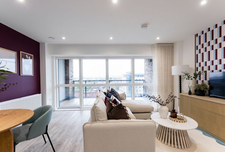 A living room with a sofa, coffee table, and large windows.